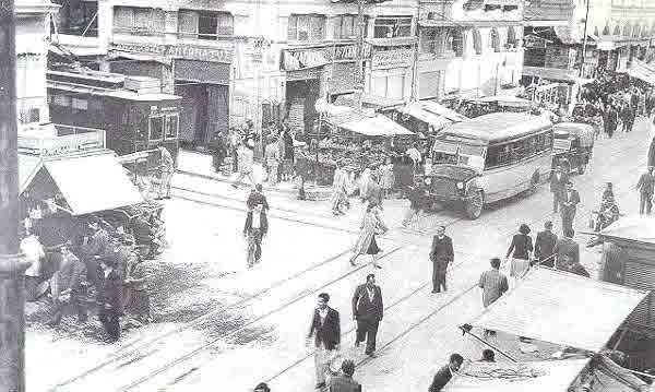 Η οδός Αθηνάς, το 1952. Χαρακτηριστικά τα αυτοκίνητα, αλλά και το λεωφορείο τής εποχής. Επειδή η Αθήνα είχε τραμ από το 1882 μέχρι και το 1960, στην φωτογραφία διακρίνεται το τραμ και οι γραμμές του.