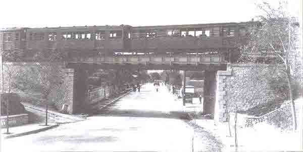 Athens 1956. The new "Ano Patisia/Agia Varvara" station, new bridge and the wooden train cars of the electric railway. Halkidos Street is almost deserted.